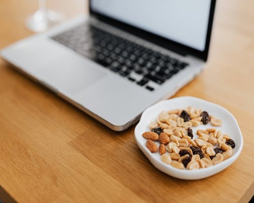 Glass of water and healthy snack on a wooden desk